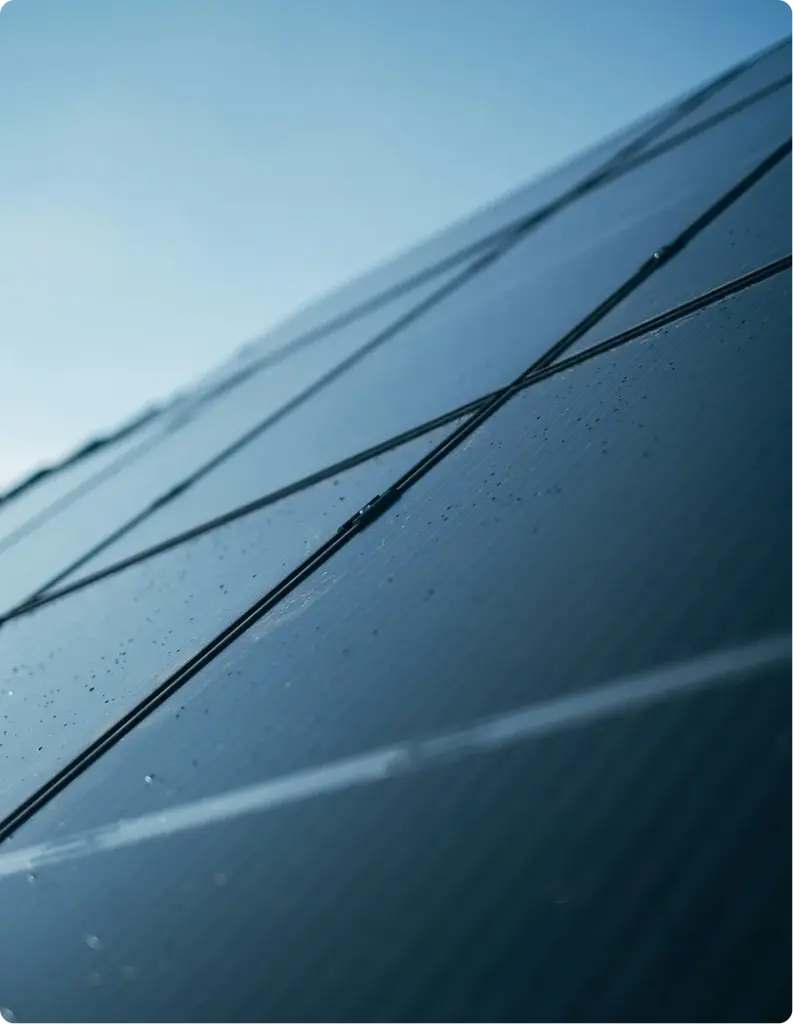 Close-up of angled solar panels with raindrops.
